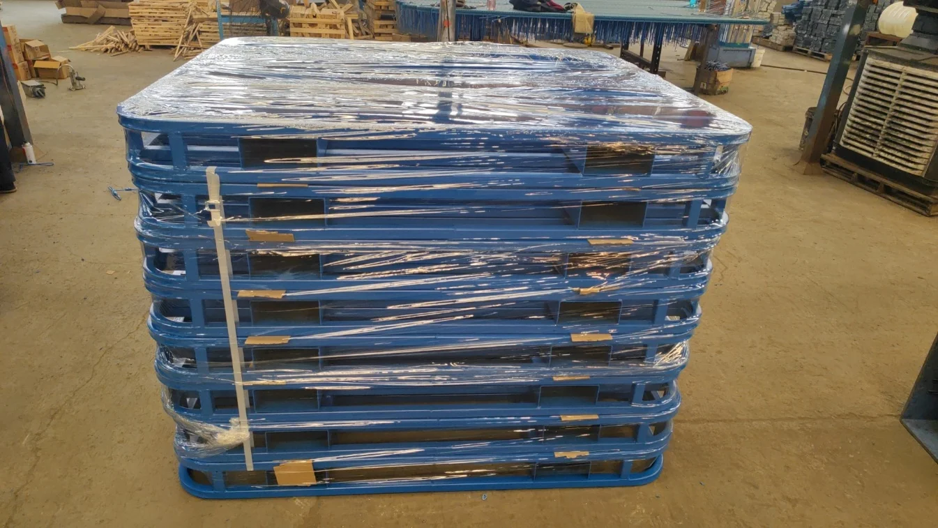 Estantes apilables de metal azules envueltos y apilados en un área de carga de fábrica