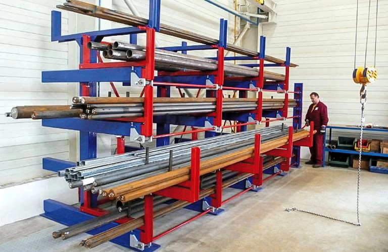 Heavy-duty telescopic cantilever rack storing long steel pipes in warehouse, manual crank operation