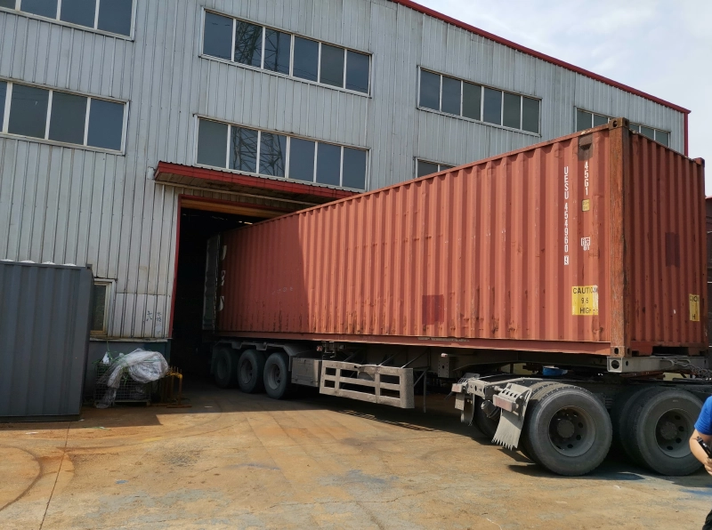 Container trailer backing into a warehouse loading dock for factory shipment