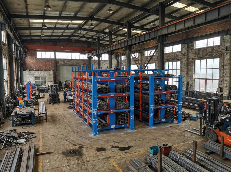 Factory-installed telescopic cantilever rack with blue uprights and red arms storing long steel bars