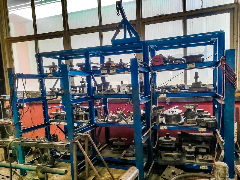 Blue Q235B three-post mold rack with overhead crane hook and multi-tier roll-out trays in a workshop