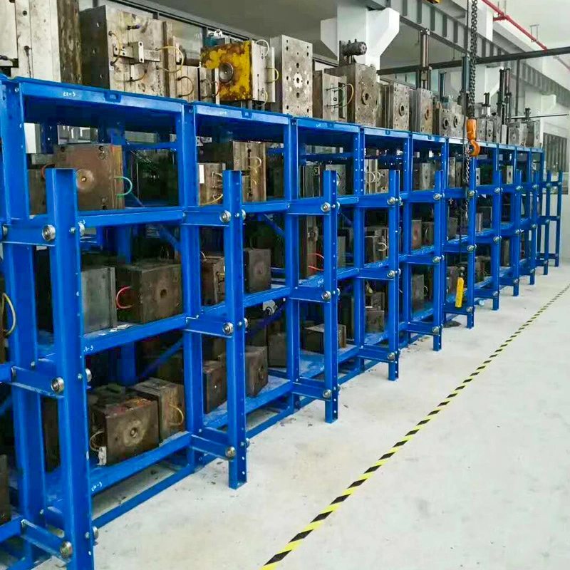 Blue roll-out mold racks with overhead crane access in an industrial workshop aisle
