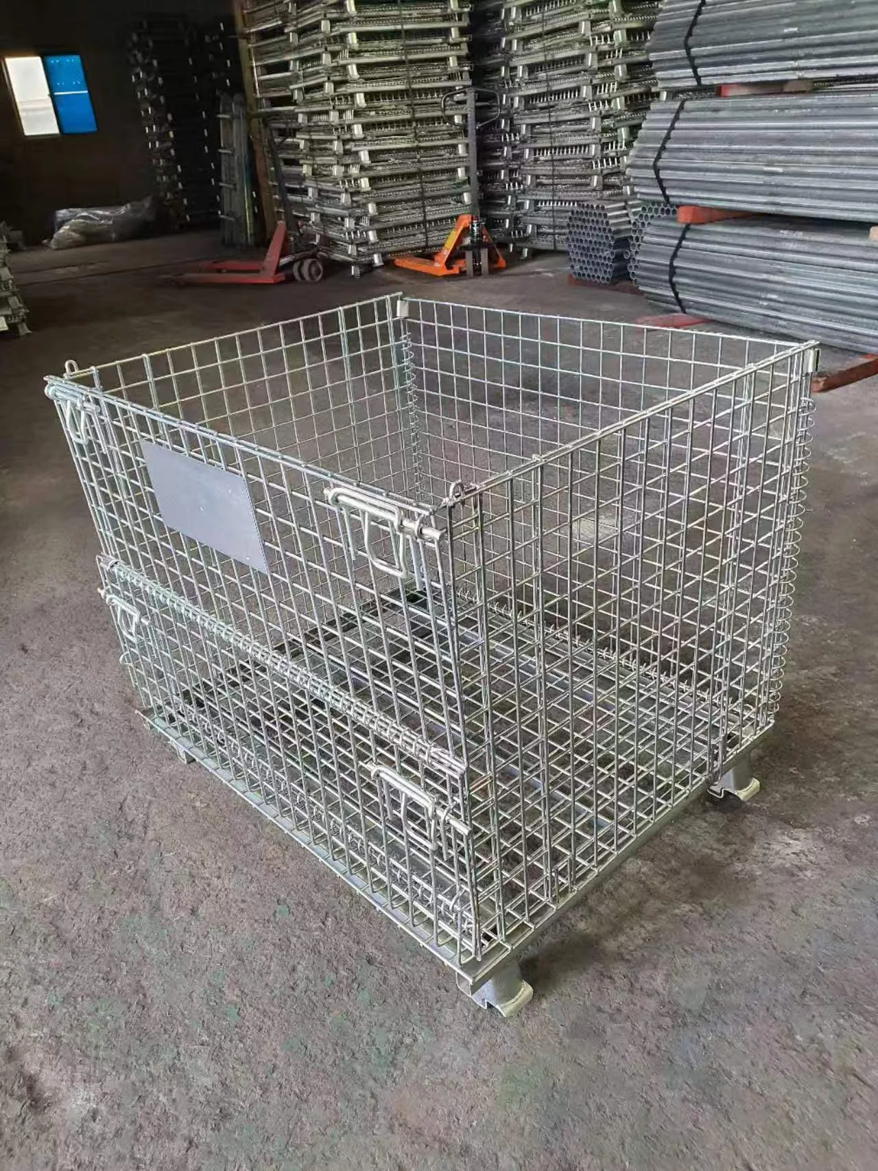 Assembled carbon steel wire mesh container positioned on a semi-outdoor cement warehouse yard floor.