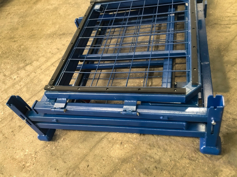 Close-up van ingeklapte eindstijl en stapelvoet van blauwe stalen container