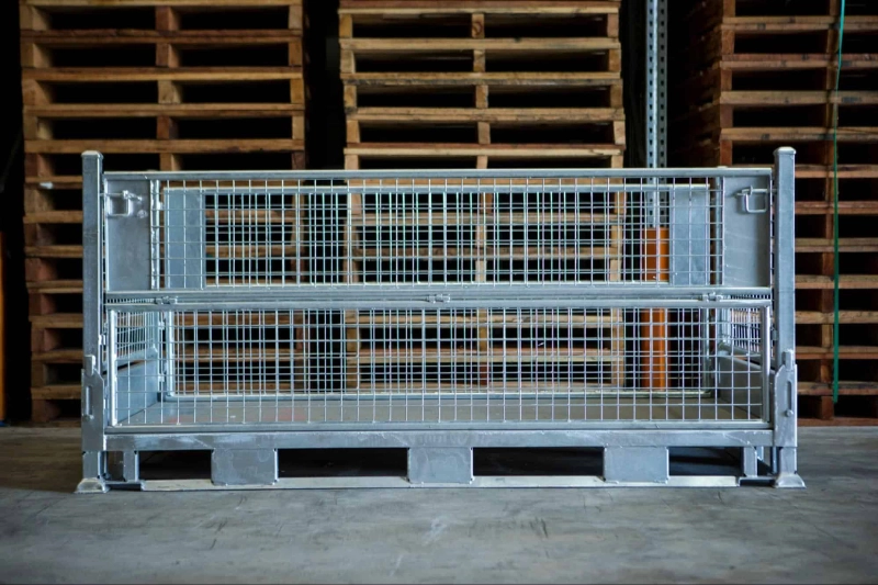 Gegalvaniseerde draadgaas stillage container in magazijn met houten pallets op de achtergrond