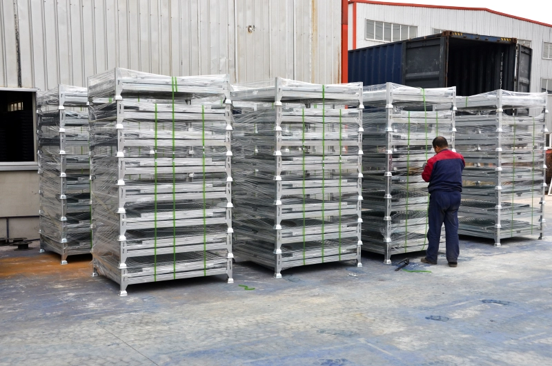 Stacked and plastic-wrapped folded steel cages ready for shipping container loading
