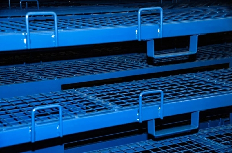 Detailed shot of stacked blue steel pallet racks with heavy wire mesh decks and pull rings