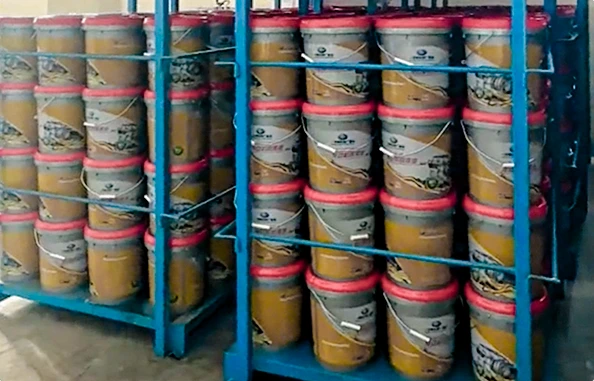 Blue steel stacking racks with side containment bars storing grey plastic pails with red lids in warehouse