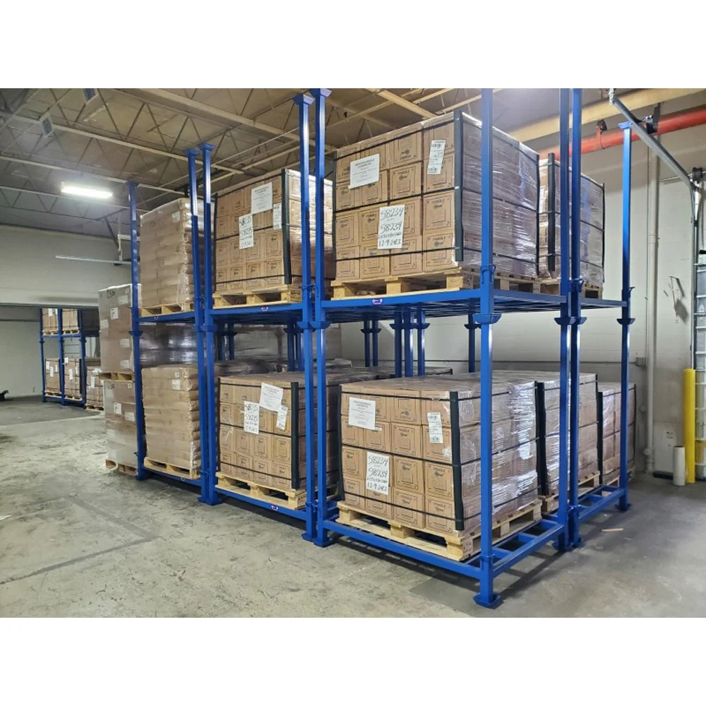 Two tier stacked blue steel nestainer racks holding carton boxes on wooden pallets wrapped in stretch film