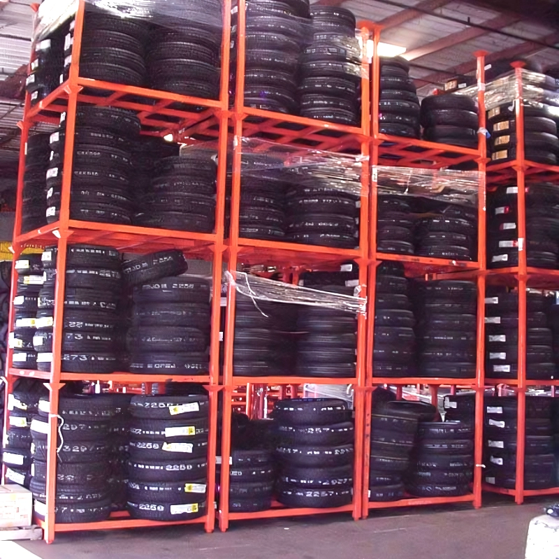Red modular storage racks holding tires in multiple levels