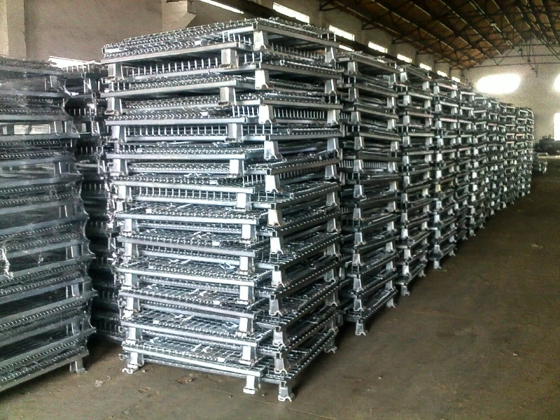 Hundreds of folded steel wire containers stacked in warehouse columns ready for export shipment.